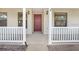 Inviting front porch with white railings and a red front door at 6819 Stafford Rd, Plant City, FL 33565