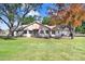 Back exterior of the house showcasing a large yard and mature trees at 6819 Stafford Rd, Plant City, FL 33565