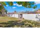 Spacious backyard with grassy lawn, white fence, and solar panels at 7262 55Th N Ave, St Petersburg, FL 33709