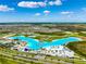 Aerial view of Crystal Lagoon amenity with beach and surrounding community at 7853 Roma Dune Dr, Wesley Chapel, FL 33545