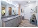 Double vanity bathroom with grey cabinets and modern fixtures at 7853 Roma Dune Dr, Wesley Chapel, FL 33545