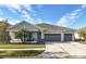 Two-story house with gray siding, three-car garage, and landscaped lawn at 7853 Roma Dune Dr, Wesley Chapel, FL 33545