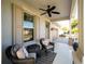 Relaxing front porch with wicker chairs and ceiling fan at 7853 Roma Dune Dr, Wesley Chapel, FL 33545