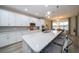 Modern kitchen with white cabinets, quartz countertops and island with seating at 7853 Roma Dune Dr, Wesley Chapel, FL 33545