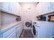 Bright laundry room with washer, dryer, and ample cabinet storage at 7853 Roma Dune Dr, Wesley Chapel, FL 33545