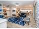 Spacious living area flows into kitchen, featuring a blue area rug and comfortable seating at 7853 Roma Dune Dr, Wesley Chapel, FL 33545