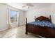 Bright bedroom with wood flooring, large window, and ceiling fan at 8919 N River Rd, Tampa, FL 33635