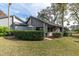 Landscaped yard and exterior of home with gray siding at 90 S Highland Ave # 12, Tarpon Springs, FL 34689