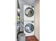 Stackable LG washer and dryer in a well-lit laundry room with shelving at 9209 Seminole Blvd # 138, Seminole, FL 33772