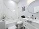 Modern bathroom with marble tile, a bathtub and a white vanity at 1103 S Prospect Ave, Clearwater, FL 33756