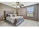 Comfortable bedroom with a ceiling fan and large window, featuring a gray bed frame and bedding at 11127 Hudson Hills Ln, Riverview, FL 33579