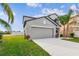 Two-story house with gray siding, two-car garage, and grassy lawn at 11127 Hudson Hills Ln, Riverview, FL 33579