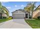 Two-story house with gray siding, two-car garage, and landscaped lawn at 11127 Hudson Hills Ln, Riverview, FL 33579