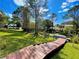 Wooden boardwalk path leading to a grassy backyard with mature trees and a glimpse of a canal at 1218 Vinetree Dr, Brandon, FL 33510