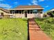 Wooden boardwalk path leading to a grassy backyard with mature trees and a glimpse of a canal at 1218 Vinetree Dr, Brandon, FL 33510