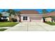 Two-story house with a two-car garage, light pink exterior, and neatly landscaped lawn at 1218 Vinetree Dr, Brandon, FL 33510