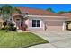 Two-story house with a two-car garage, light pink exterior, and neatly landscaped lawn at 1218 Vinetree Dr, Brandon, FL 33510