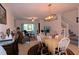 Open concept living and dining area with white chairs at 16843 Forge Surf St, Land O Lakes, FL 34638
