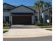 Two-story house with brown garage door and landscaped yard at 16843 Forge Surf St, Land O Lakes, FL 34638