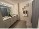 Bright bathroom featuring double sinks, vanity, neutral paint, with tiled floors at 16949 Secret Meadow Dr, Odessa, FL 33556