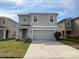 Charming two-story home with a well-maintained front yard, a two-car garage, and a welcoming entrance at 16949 Secret Meadow Dr, Odessa, FL 33556