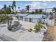 Charming coastal home featuring a metal roof, white picket fence, and tropical landscaping at 2740 E Vina Del Mar Blvd, St Pete Beach, FL 33706