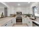 Modern white kitchen with stainless steel appliances and granite countertops at 2740 E Vina Del Mar Blvd, St Pete Beach, FL 33706