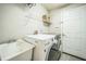 Bright laundry room, washer, dryer, utility sink, and shelving at 4709 Red Warbler Ln, Valrico, FL 33596