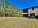 Spacious backyard with grassy area and tree line at 4899 Isola Ct, Wesley Chapel, FL 33543