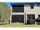 Backyard view of home with screened patio at 4899 Isola Ct, Wesley Chapel, FL 33543