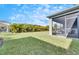Spacious backyard showcasing a screened patio and well-manicured lawn at 5612 Limelight Dr, Apollo Beach, FL 33572
