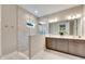 Elegant bathroom with double vanity, large mirror, and walk-in shower at 5612 Limelight Dr, Apollo Beach, FL 33572