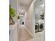 Bright hallway with light wood tile floors, leading to laundry room and bedrooms at 5612 Limelight Dr, Apollo Beach, FL 33572