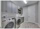 Spacious laundry room with gray shaker cabinets, quartz countertops and new appliances at 5612 Limelight Dr, Apollo Beach, FL 33572