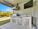 Stainless steel outdoor kitchen with granite countertop, grill, and mini-fridge at 5612 Limelight Dr, Apollo Beach, FL 33572