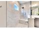 Walk-in shower with marble tile, built-in seat, and glass enclosure at 5612 Limelight Dr, Apollo Beach, FL 33572
