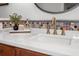 Bathroom vanity with white countertop, brass fixtures, and mosaic tile backsplash at 728 Wood St, Dunedin, FL 34698