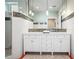 Double vanity with white cabinets, brass fixtures, and mosaic tile details at 728 Wood St, Dunedin, FL 34698