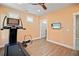 Home gym with hardwood floors, a treadmill, and a wall-mounted TV at 728 Wood St, Dunedin, FL 34698