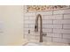 Modern laundry room sink with a sleek faucet and white brick backsplash at 728 Wood St, Dunedin, FL 34698