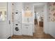 Laundry room with stackable washer and dryer, white cabinets, and a small sink at 728 Wood St, Dunedin, FL 34698
