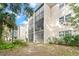 Building exterior showcasing screened balconies and lush landscaping at 845 Maple Ct # 107, Dunedin, FL 34698