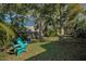 Green backyard with lush tropical plants and two chairs at 1120 Idlewild N Dr, Dunedin, FL 34698