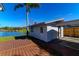 Backyard with detached workshop, carport, and deck overlooking water at 11416 Pine Forest Dr, New Port Richey, FL 34654