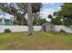 Backyard features a white privacy fence, storage shed, swing, firepit, and large shade tree at 12840 Sophia Cir, Largo, FL 33774