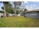 Spacious backyard with lush green grass, a storage shed, and room for outdoor activities at 12840 Sophia Cir, Largo, FL 33774