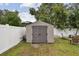 Backyard shed against a white fence with a table and chairs for outdoor activities at 12840 Sophia Cir, Largo, FL 33774