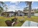 Spacious backyard featuring a screened-in pool, fire pit, and a large tree providing ample shade at 12840 Sophia Cir, Largo, FL 33774