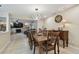 The dining area features a wooden table with an ornate chandelier, tile floors, and a view into the cozy living room at 12840 Sophia Cir, Largo, FL 33774