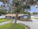 Quaint one-story home boasts a stone facade, mature landscaping, and inviting curb appeal at 12840 Sophia Cir, Largo, FL 33774